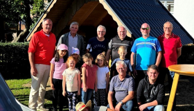 Gemeinschaftsfoto vor dem neuen Blockhaus. Einige Kinder, die freiwilligen Handwerker und Mandatsträger der gemeindlichen Gremien.