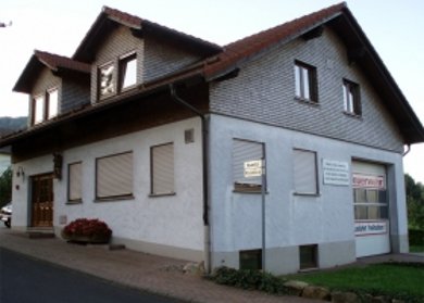 Feuerwehrhaus Abtsroda Feuerwehrhaus in Abtsroda mit rotem Tor und gepflastertem Vorplatz.