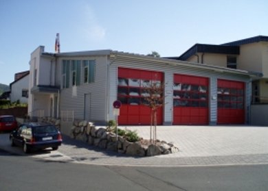 Feuerwehrhaus Poppenhausen Feuerwehrhaus Poppenhausen mit zweigeschossigem Gebäude und verschlossenen Fenstern.