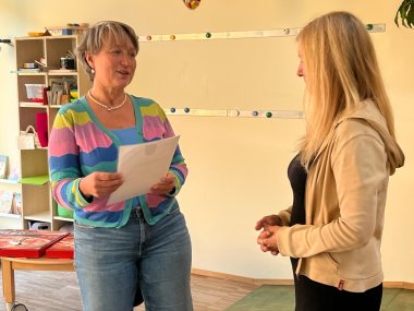 Bürgermeisterin Alexandra Ballweg hält die Urkunde in der Hand, Alexandra Ballweg steht vor Barbara Böhm-Zentgraf und hält Grußworte und eine kleine Ansprache über die Jubilarin.